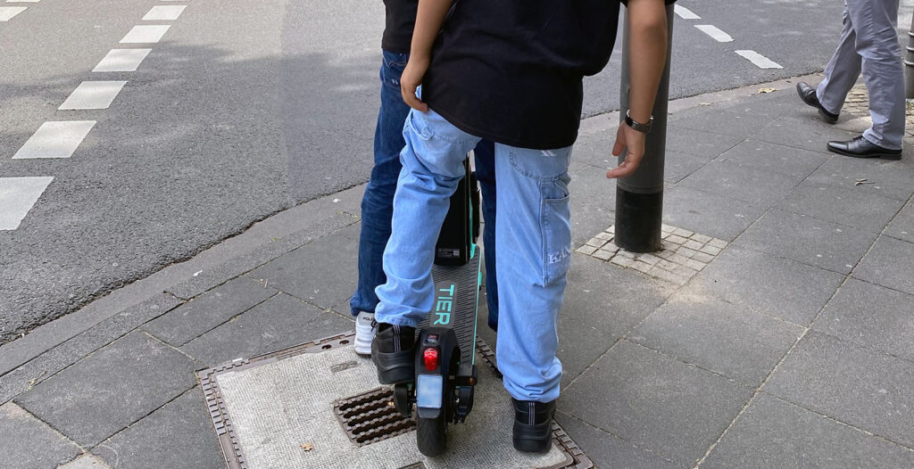 Zwei Jugendliche auf einem E-Scooter