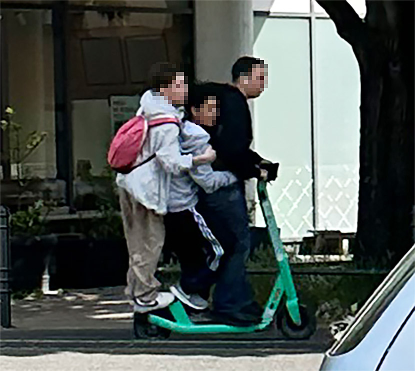 Drei Personen fahren auf einem E-Scooter